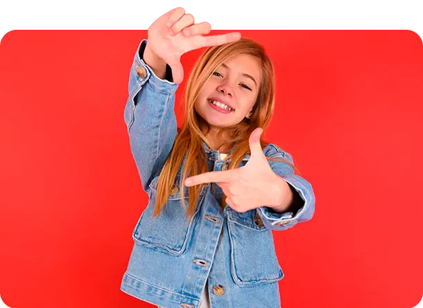 Niña con los dedos indice y pulgar de ambas manos como si estuviera enfocando con una cámara